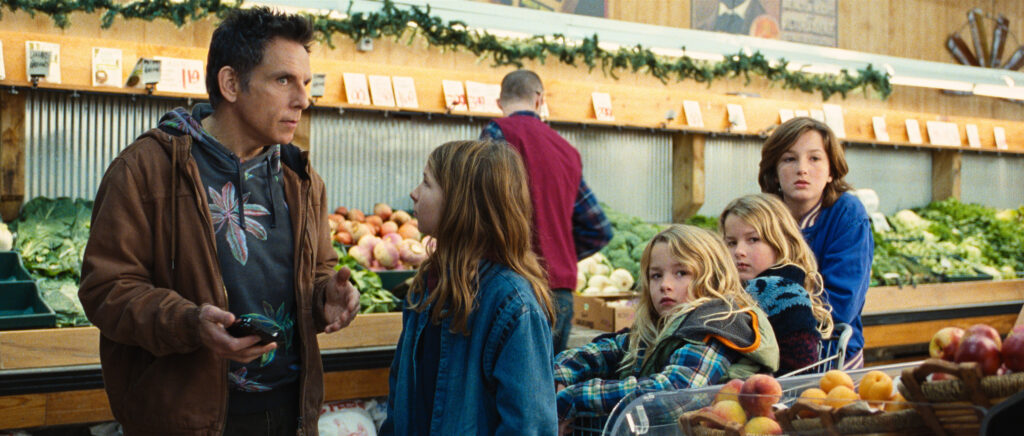 A scene from Nutcrackers set in a grocery store, featuring a man speaking animatedly to a young girl while three other children look on, one sitting in a shopping cart