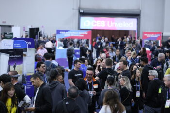 Crowded CES 2026 show floor with attendees networking and exploring technology exhibits, startup booths, and product displays at a busy industry event.