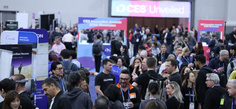 Crowded CES 2026 show floor with attendees networking and exploring technology exhibits, startup booths, and product displays at a busy industry event.